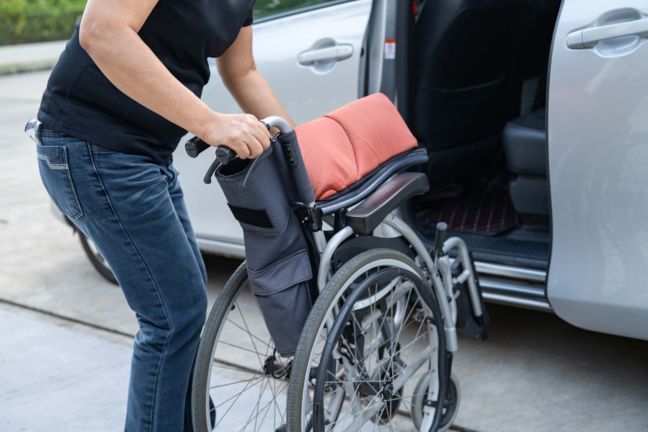 Customer stowing a wheelchair in a van, showing need for reliable wheelchair transportation funding.