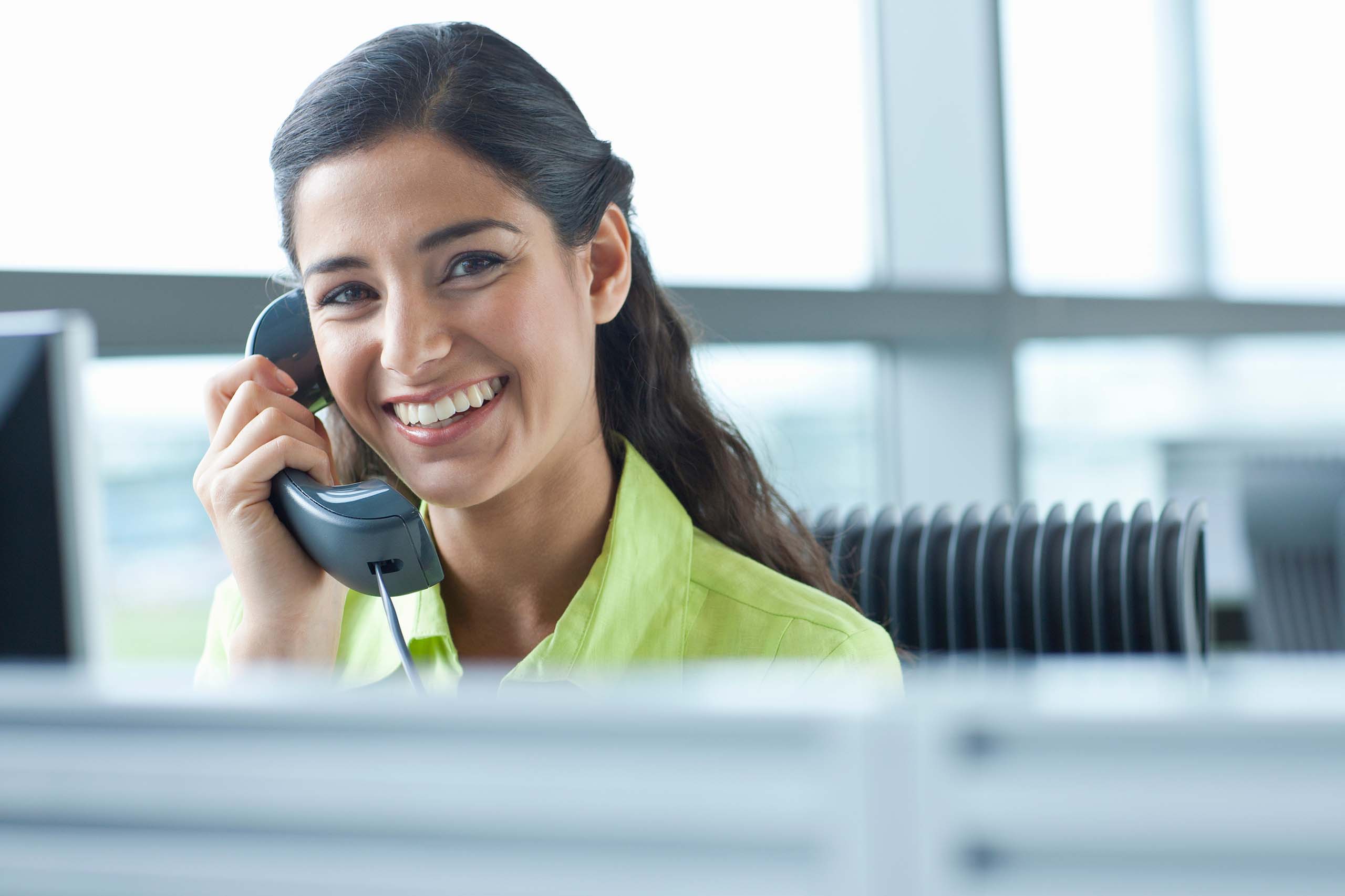 Professional team member communicating with clients at a desk. MMB Solution Development staff providing expert solutions.